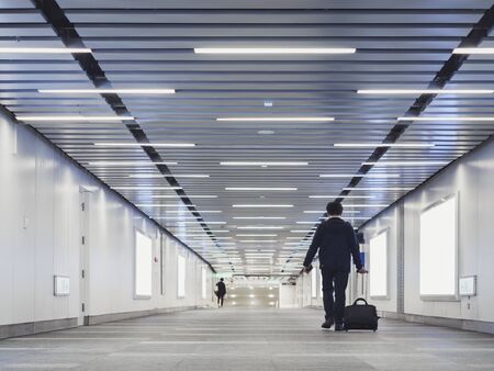 People walking hall walkway airport Asian traveler with luggage Modern building indoor perspective with Media bannerの写真素材