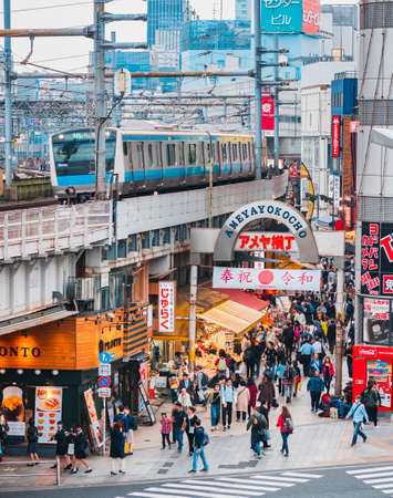 JAPAN, TOKYO - APR 19, 2019 : Ueno shopping street Ameyoko Market entrance with JR rail on train track Crowd tourist Tokyo shopping streetのeditorial素材