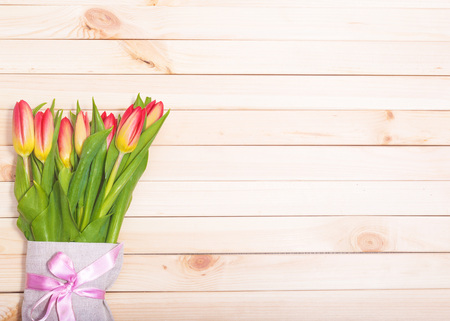 Fresh tulips on a background of light wooden boardsの写真素材