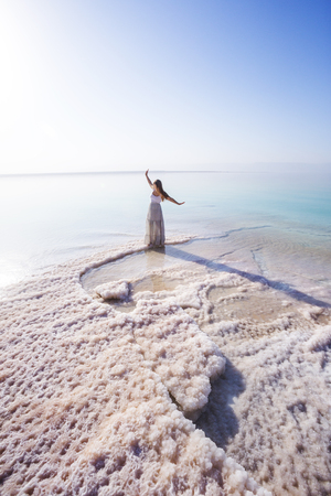 Blonde young girl in a long skirt on the shore of the dead sea. Jordanの写真素材