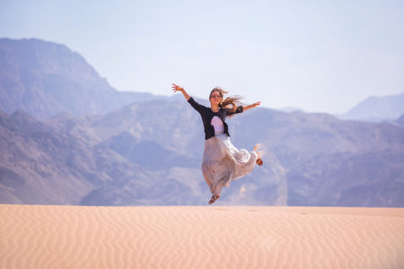 Woman standing on a sand dune in the desert of Jordan