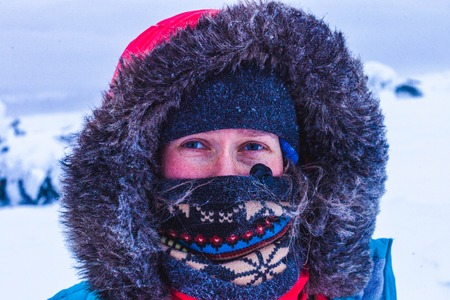 Portrait of a girl in the mountains in winter. Face covered with scarfの写真素材