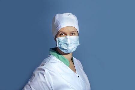 doctor girl in a protective mask on a background of blue wallの写真素材