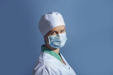 doctor girl in a protective mask on a background of blue wallの写真素材