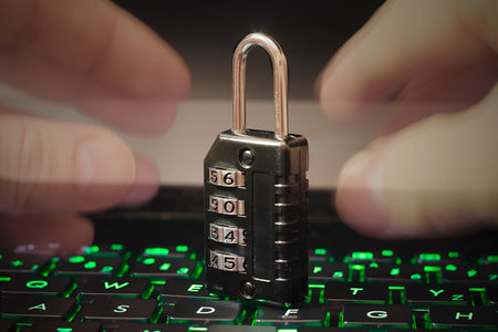 Hands trying to open combination Code Padlock on laptop keyboard