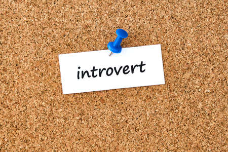 Introvert. Word written on a piece of paper or note, cork board background.の写真素材