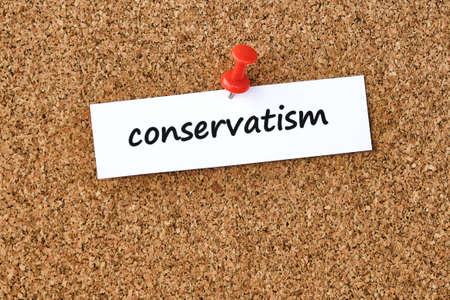 Conservatism. Word written on a piece of paper, cork board background.の写真素材