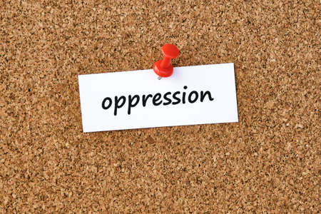Oppression. Word written on a piece of paper, cork board background.の写真素材