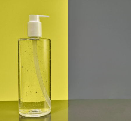 Hand sanitizer bottle isolated on a modern yellow and gray backgroundの写真素材
