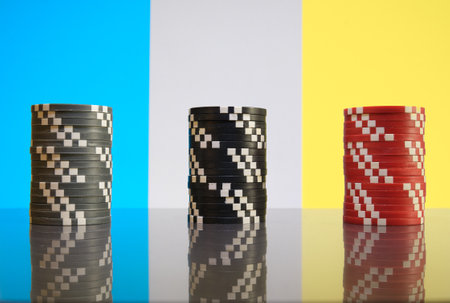 Stacks of red, black and gray casino chips on colorful background close-upの写真素材