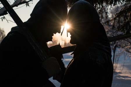Silhouettes of two medieval warriors in the winter forestの写真素材
