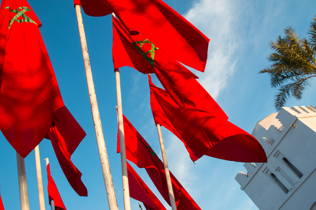 Moroccan flags in Marrakech on a background of blue skyの写真素材