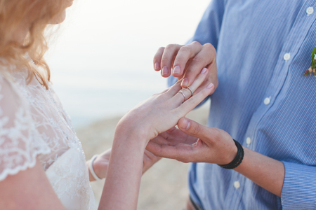 man wears  wedding ring on the finger of  girlの写真素材