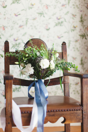 Beautiful white and green bouquet on a wooden chairの写真素材