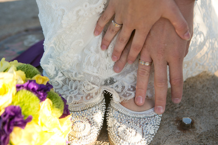 Bride and groom holding hands, wedding ringsの写真素材