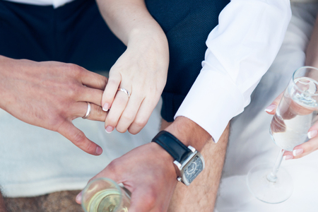 Newlyweds with glasses of champagne on hand close-upの写真素材