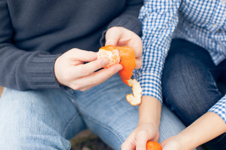 Young couple eating mandarins close-up