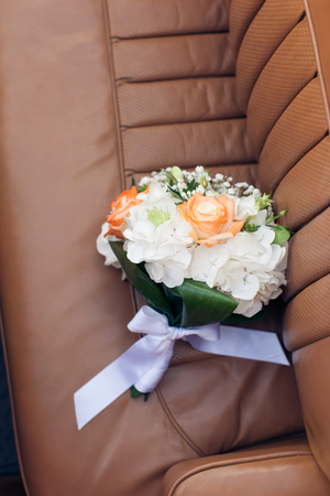 Wedding bouquet on a leather car seat close-upの写真素材