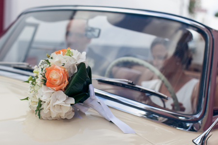 Wedding bouquet on a retro car bonnet close-upの写真素材