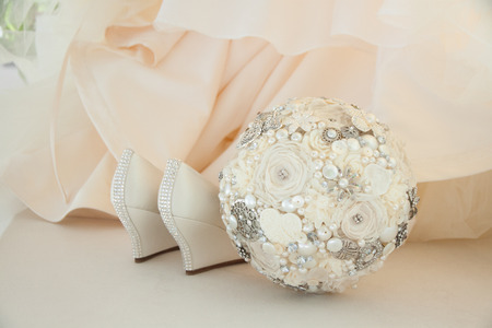 White wedding shoes and modern wedding bouquet close-upの写真素材
