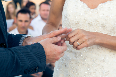 The bride wears a ring on the finger of the bride close-upの写真素材
