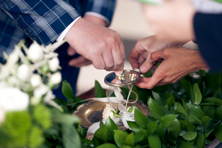 The groom takes wedding ring on ceremony close-upの写真素材
