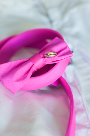 Wedding rings and pink bow tie close-upの写真素材