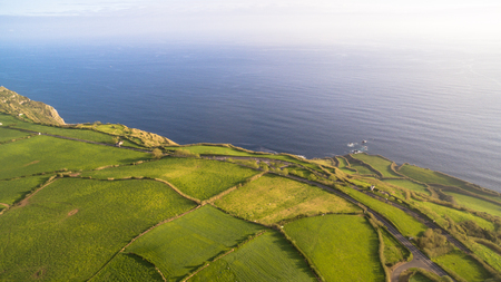 Green fields of Azores with atlantic ocean on backgroundの写真素材