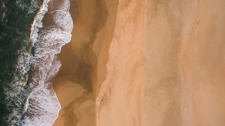 Aerial view of ocean sea waves on sandy beach at eveningの写真素材