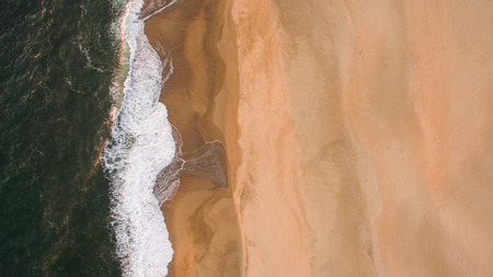 Aerial view of ocean sea waves on sandy beach at eveningの写真素材
