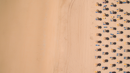 Aerial view of empty sandy beach with sun umbrellasの写真素材