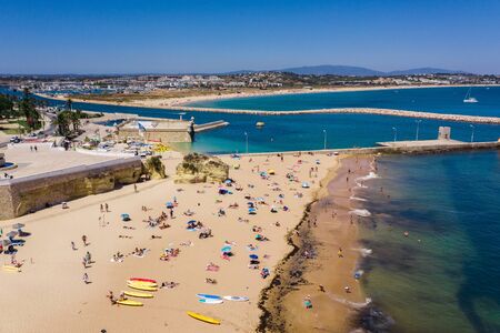 Tourists relaxing on Praia da Batata beach, Lagos, Algarve, Portugal, Europe, aerial drone wide viewの写真素材