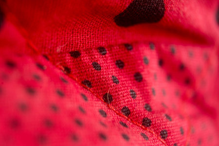 macro texture of red fabric with small holes, can be used as backgroundの写真素材