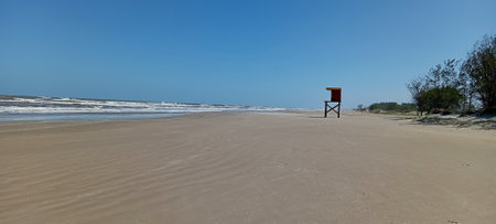Panoramic view of a beach with a lifeguard chair in the foregroundの写真素材
