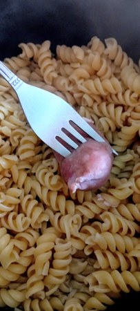 Fusilli pasta with meat ball on a fork, close upの写真素材