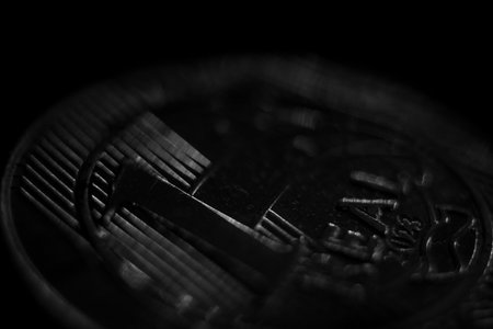Close-up of a real coin on a dark background. Monochromeの写真素材