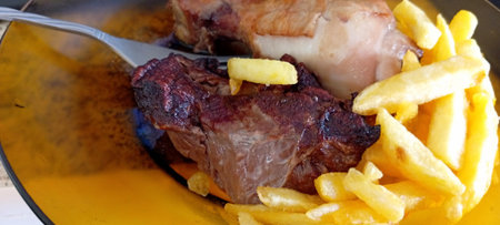 Close up of beef steak with french fries in a bowl on wooden tableの写真素材