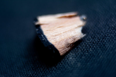 Wooden pencil on a black background close-up macro photography.