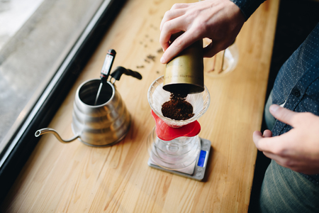 Picthers, coffee and hands on the desk near windowの写真素材