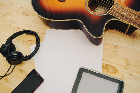 Office desk background, Hand written touchscreen on tablet PC with acoustic guitar, headphones recording scene project ideas concept. mobile phones, View from above with copy space. Colorの写真素材