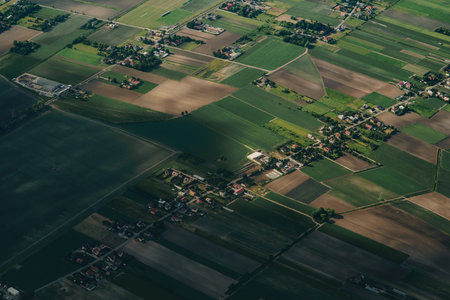 Aerial agriculture landscape with river and farms , village. Land, sun, clouds