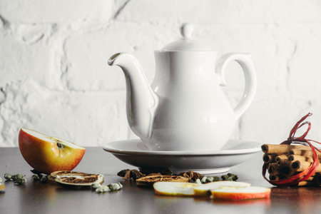 Tea cups with teapot on old wooden table. Fruit ginger hot drink. White background.の写真素材