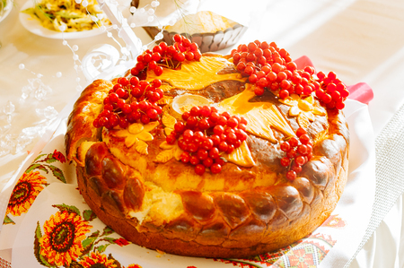 White wedding cake with flowers and blueberries on tableの写真素材