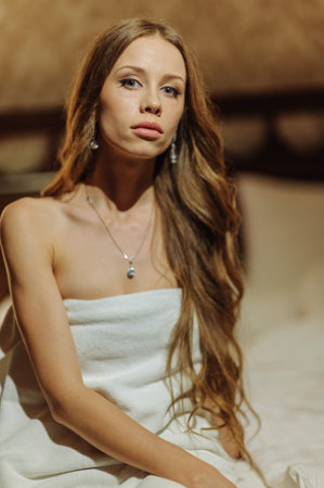 Spa woman. Beautiful girl after bath. Perfect skin. Skincare. Young skin. Beauty lady wearing in white towelsitting on bed. Pampering. Treatmentの写真素材