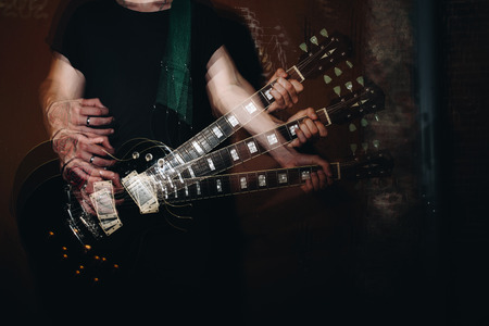 Speed music. Guitar neck close-up on a concert of rock music in the hands of a musician. Double exposureの写真素材