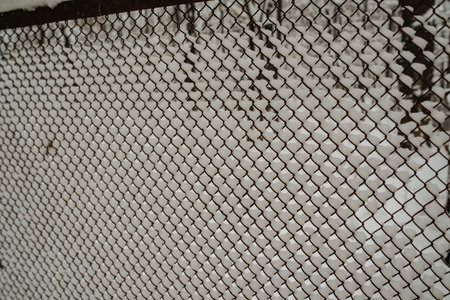 The border of country marking road and fence of land in winter. Refugee and migrant. Winter snow on...