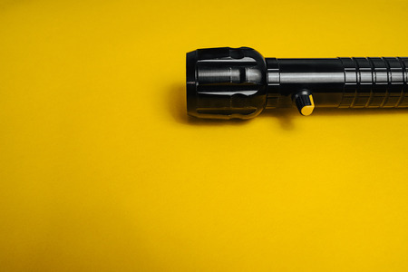 Travel and Search. Close-up of a flashlight on yellow background.の写真素材