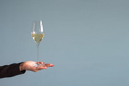 Woman holding a wine glass with wine in hand. Copy spaceの写真素材