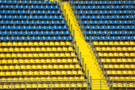 Blue and yellow empty stadium seatsの写真素材