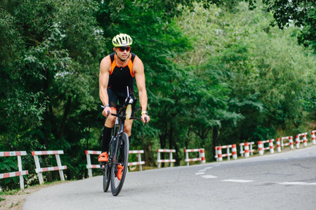 KHARKIV, UKRAINE - August 2, 2020: Triathon biking cyclist triathlete riding racing bike during ironman competition. Road cycling athlete in tri suit and helmet. Public events are allowed. Europe sport during CV pandemic.のeditorial素材